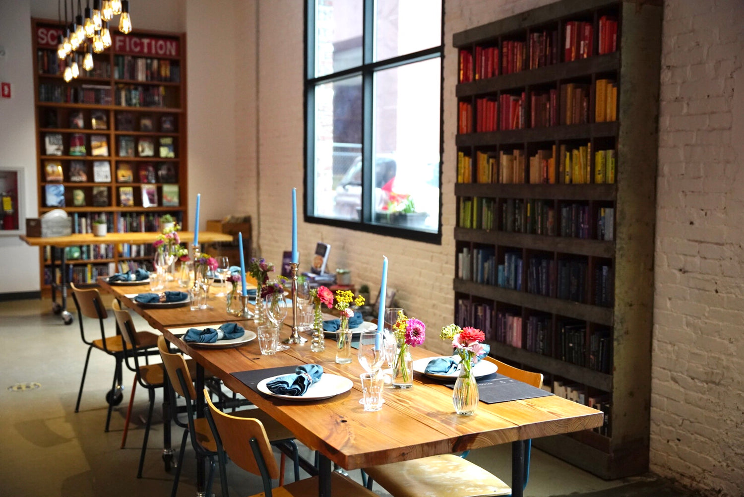 A formal dining setup in a bookstore, adorned with elegant bookshelves and a meticulously arranged table
