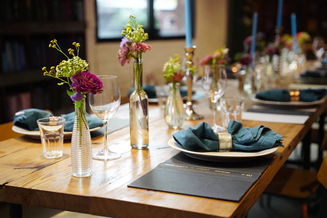 A long wooden table adorned with an abundance of glassware