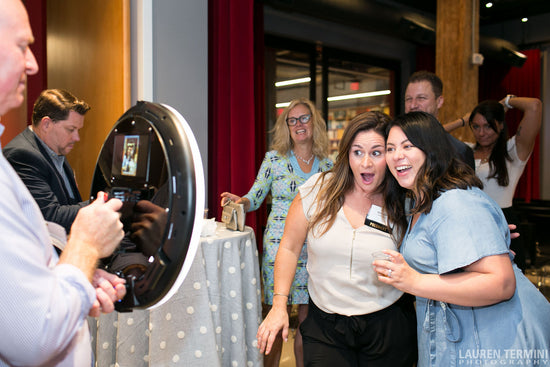 Two women capturing a self-portrait at a lively event