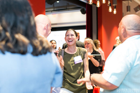 At a social event, a woman's infectious laughter resonates as she enjoys the company of fellow attendees