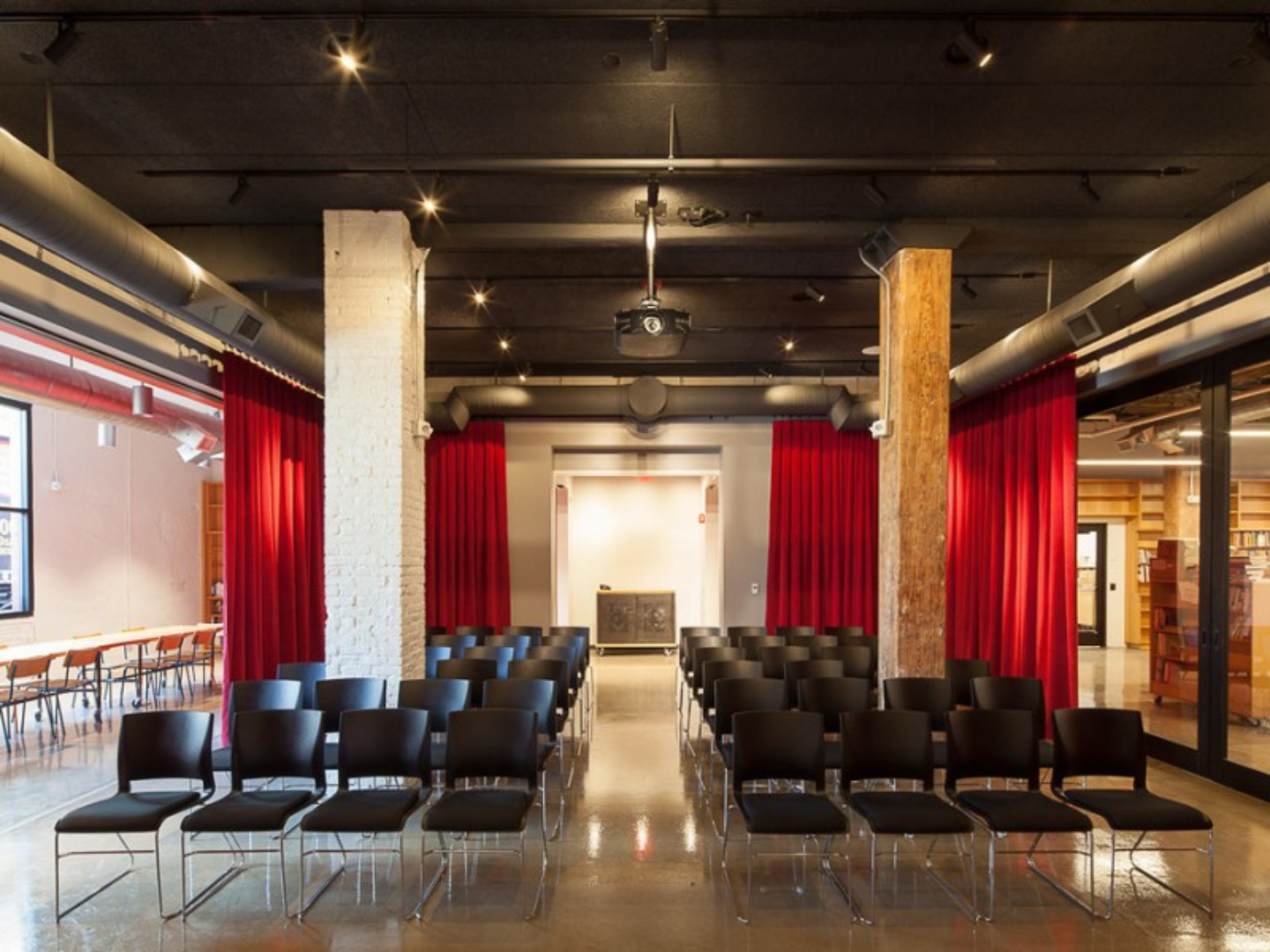 A spacious room with comfortable chairs and vibrant red curtains adorning the windows